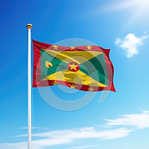 Waving flag of Grenada on flagpole with sky background.