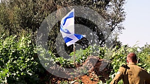 Waving flag of Israel, Israeli soldier runs up to the flag, sits on his knee and salutes the main symbol of Israel