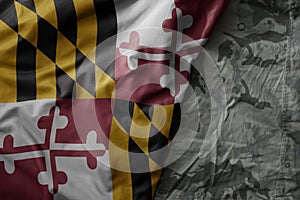 waving flag of maryland state on the old khaki texture background. military concept