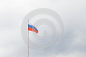 Waving flag of Russia against gloomy cloudy sky