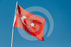 Waving flag of Turkey against a blue sky