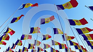 Waving Flags of Andorra against blue sky.