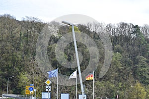 waving flags of the European Union, Germany and village Wellen