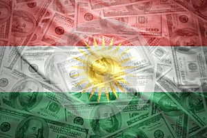 Waving kurdish flag on a american dollar money background