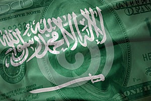 waving national flag of saudi arabia on a american dollar money background. finance concept