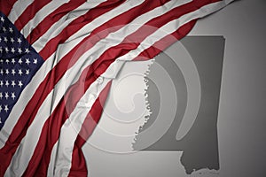 Waving national flag of united states of america on a gray mississippi state map background.