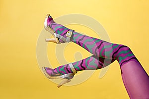 Waving sexy female legs in multicolored purple collant