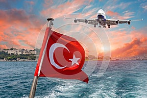 Waving Turkish flag on a ferry boat against Bosporus or Strait of Istanbul and flight airplane landing airport sky