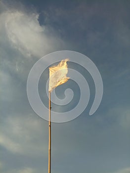 waving white flag against the blue sky background