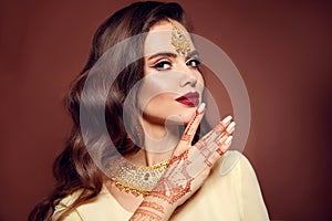 Wavy hair. Portrait of beautiful girl with indian jewelry. Young woman model with kundan golden bijouterie set. Traditional Indian