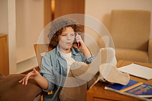 A wavy-haired boy posing as a big boss