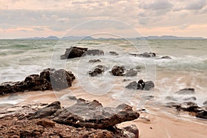 wavy sea with rocks near a beach