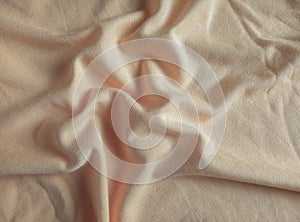 wavy surface of beige cotton fabric.