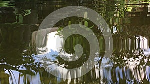 Wavy water surface with reflection of trees