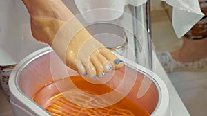 Wax bath for feet at beauty spa salon, close-up. photo