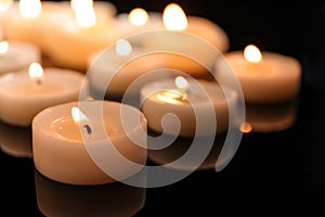 Wax candles burning on table in darkness