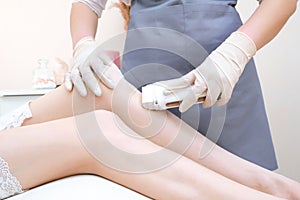Wax depilation of legs, depilation of a young woman