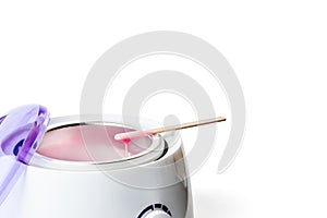 Wax heater with hot pink wax and a spatula