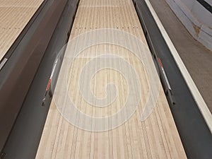 Waxed wooden bowling alley lanes with bumpers