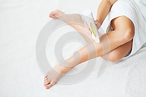 Waxing. Beautician Waxing Woman`s Leg In Spa Salon