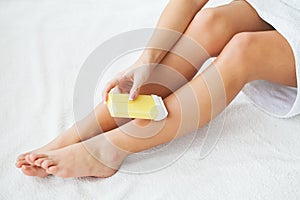 Waxing. Beautician Waxing Woman`s Leg In Spa Salon