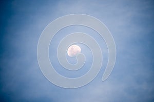 Waxing gibbous moon at night with illuminated sky