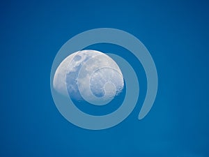 Waxing gibbous phase of the moon on a blue sky at daytime