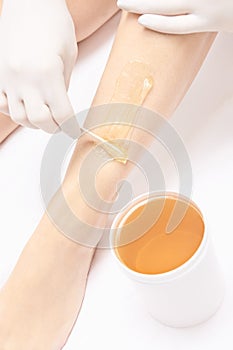 Waxing woman leg. Sugar hair removal. laser service epilation. Salon wax beautician procedure