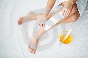 Waxing. Young Woman Depilating Her Leg With Wax Stripe