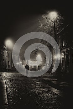 On the way home - single man on the Baklandet foggy streets, night walk in Trondheim`s old town