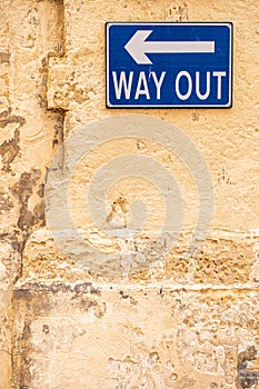 Way Out blue sign on a wall