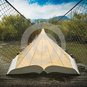 Way by the suspension bridge on the pages of book