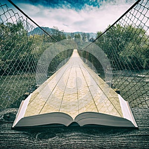 Way by the suspension bridge on the pages of book, vintage