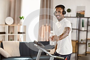 Way to health. Handsome african american man athlete preparing for cardio training on treadmill