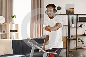 Way to health. Handsome african american man athlete preparing for cardio training on treadmill