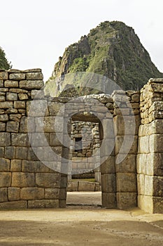 Wayna Picchu behind ruins of doors inside Machu Picchu