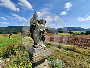 wayside roadside shrine in the landscape of fields and forests in the sudetes mountains