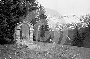 A wayside shrine on an alpine meadow near Lenzerheid, shot with black and white film technique