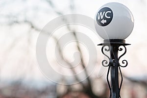 Wc sign on street light pillar in Prague