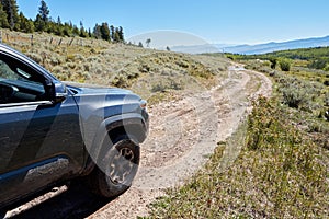 4WD vehicle driving on a narrow dirt road