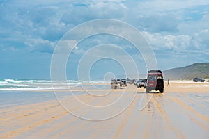 4wd vehicles at Rainbow Beach with coloured sand dunes, QLD, Australia