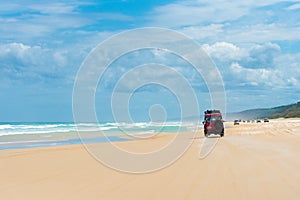 4wd vehicles at Rainbow Beach with coloured sand dunes, QLD, Australia