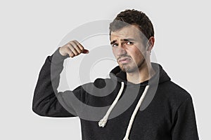Weak caucasian young man is looking into the camera disappointedly. Isolated on white background. Weakness concept