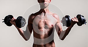 Weak man lift a weight, dumbbells, biceps, muscle, fitness. Nerd maleraising a dumbbell. Man holding dumbbell in hand