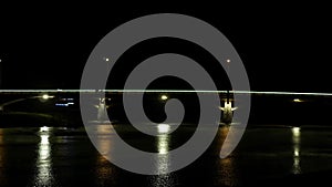 The weak movement of cars through a small bridge illuminated at night