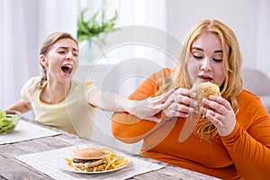 Weak-willed fat woman eating a sandwich