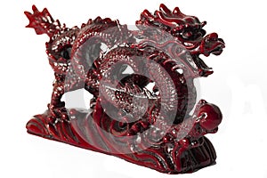 Wealth and power symbolized by the fengshui styled mystic dragon red statue with a clipping path. Feng Shui is a Chinese