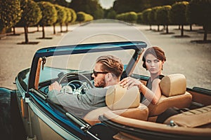 Wealthy couple in classic convertible