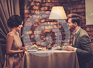 Wealthy couple enjoying meal at restaurant.