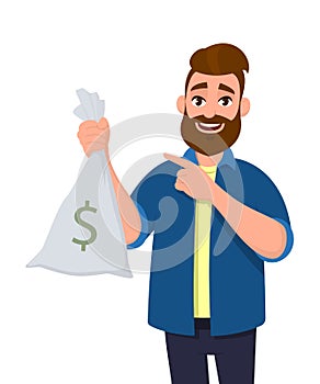 Wealthy and successful young man is holding money, cash bag in hand and pointing hand index finger towards. Business, banking.